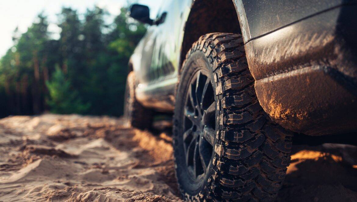 SUV car at the off road close up view of the wheel