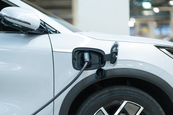 Power cable pump plug in charging power to electric vehicle EV car with modern technology UI control information display, car fueling station connected power cable alternative sustainable eco energy