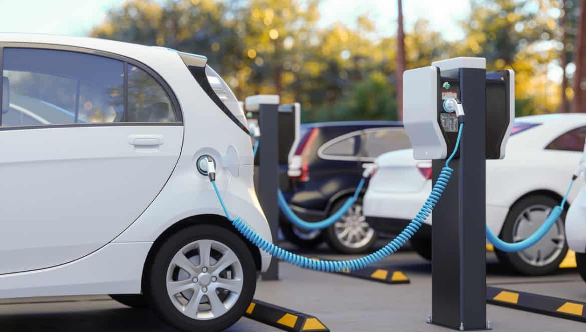 Clean Energy Concept. Close-up View Of Charging Electric Car In Parking Lot