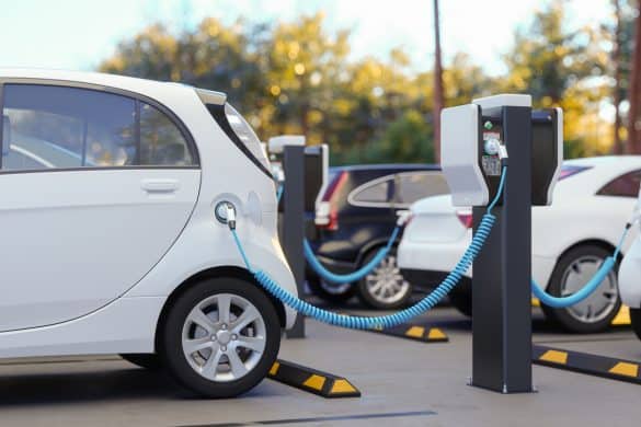 Clean Energy Concept. Close-up View Of Charging Electric Car In Parking Lot