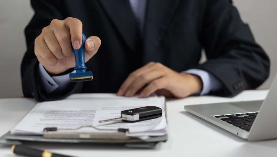 Businessman signing a contract for buying of selling a car.Car rental service. insurance, and contract agreement concepts