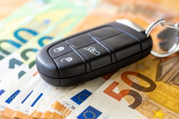 Car keys and Euro banknotes. Business concept. Car insurance, Parking zone, EU transport regulations, Leasing, Car loan, transportation costs, toll roads. close up