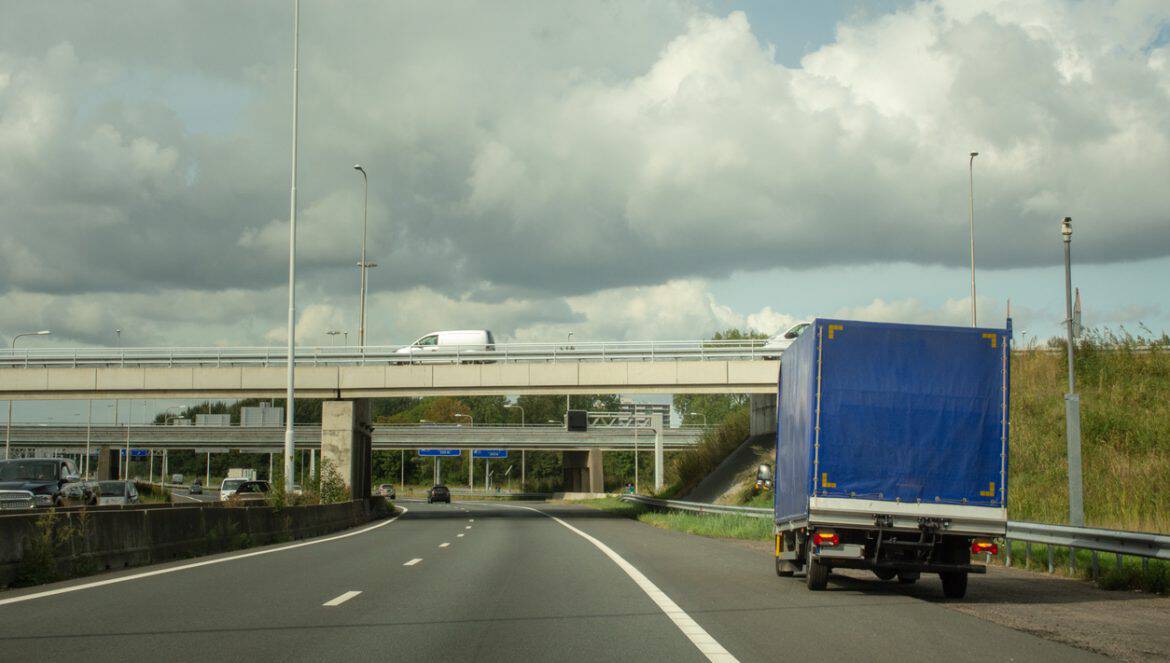 Small blue transporter having car trouble just outside Rotterdam on the freeway