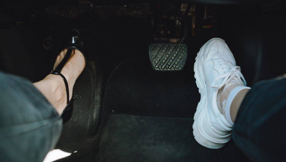 woman legs in high-heeled and sneakers shoes - choosing comfort for driving. copy space