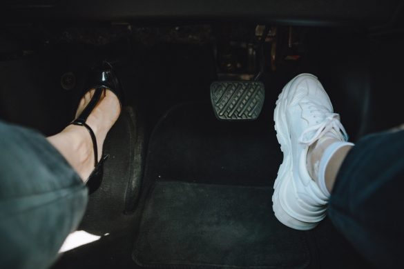 woman legs in high-heeled and sneakers shoes - choosing comfort for driving. copy space