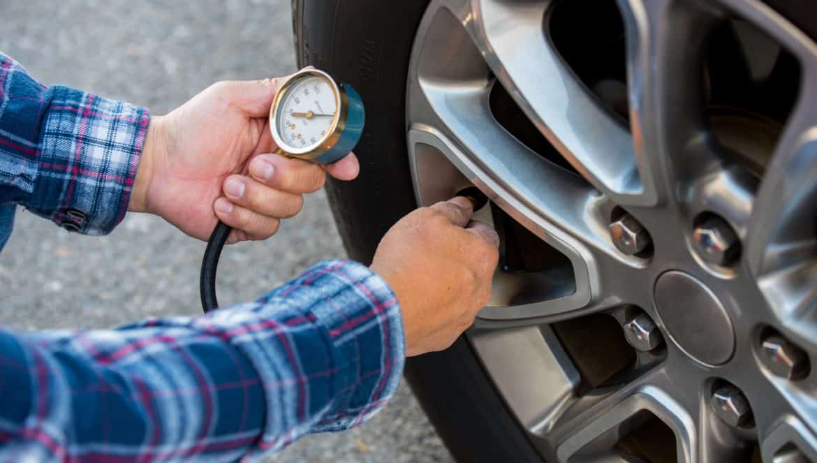 Checking tire pressure with pressure gauge