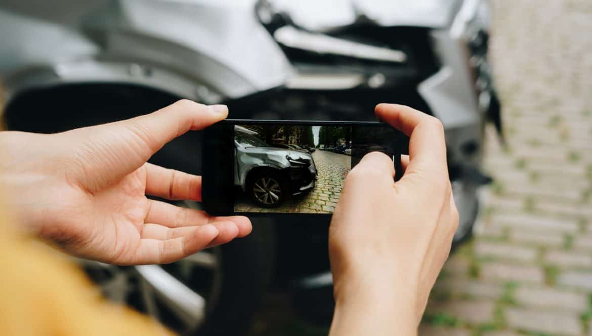 Man taking photos of the damaged car after a traffic accident