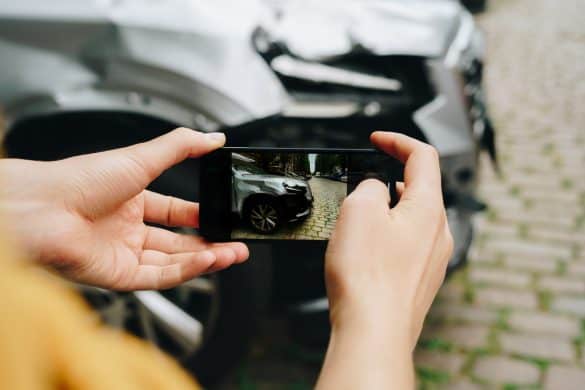 Man taking photos of the damaged car after a traffic accident