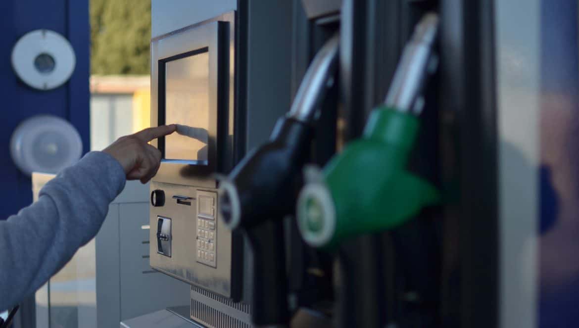A man pays the bill at a gas station with a bank card at an electronic cash register